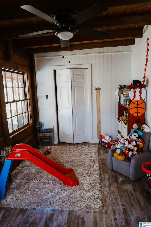 bedroom with hardwood / wood-style flooring, beam ceiling, and a closet