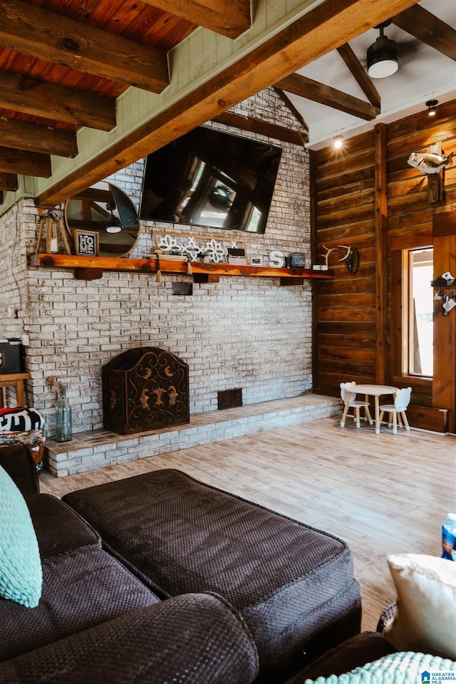 living room featuring a brick fireplace, vaulted ceiling with beams, hardwood / wood-style floors, and wooden ceiling