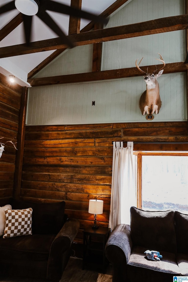 living room featuring vaulted ceiling with beams and wooden walls