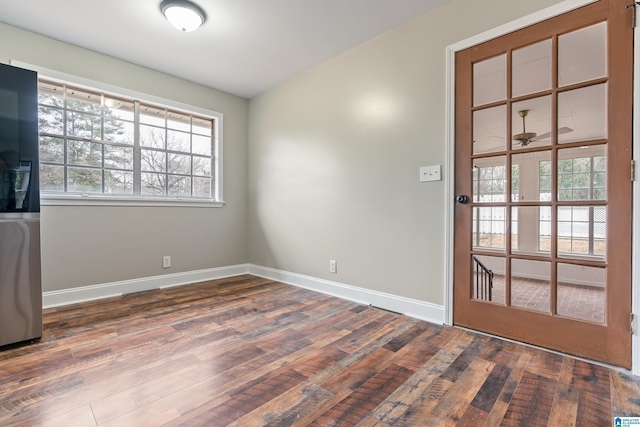 empty room with dark wood-style flooring and baseboards