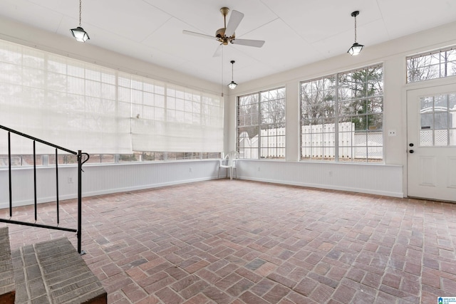 unfurnished sunroom with ceiling fan