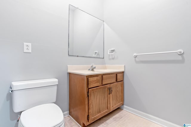 bathroom with toilet, baseboards, and vanity