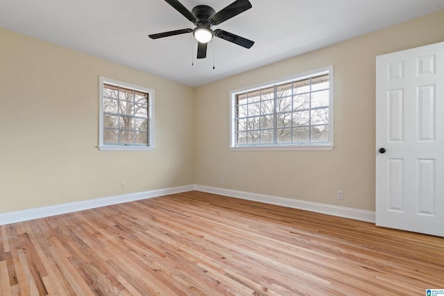 spare room with light wood-type flooring, ceiling fan, and baseboards