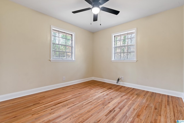 spare room with light wood finished floors, baseboards, and a ceiling fan