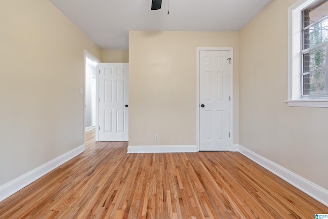 unfurnished bedroom featuring light wood-style flooring, baseboards, and a ceiling fan