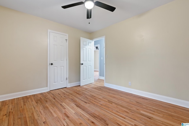 empty room with a ceiling fan, light wood-type flooring, and baseboards