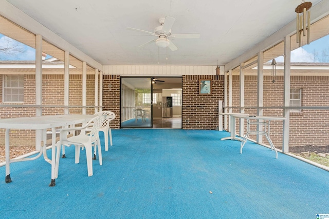 unfurnished sunroom with ceiling fan