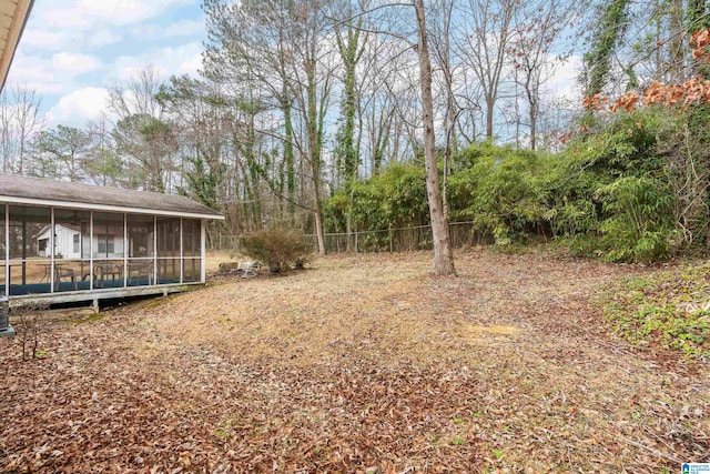 view of yard featuring a sunroom and fence