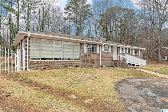 view of front of property featuring a front yard, brick siding, and fence