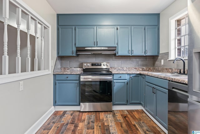 kitchen with under cabinet range hood, appliances with stainless steel finishes, blue cabinetry, and a sink