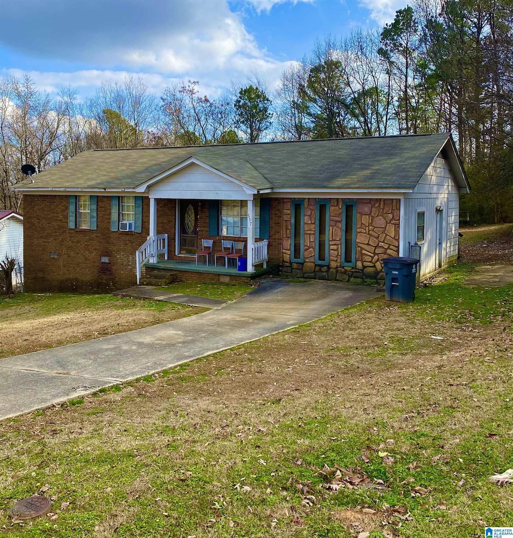 ranch-style house with covered porch and a front lawn