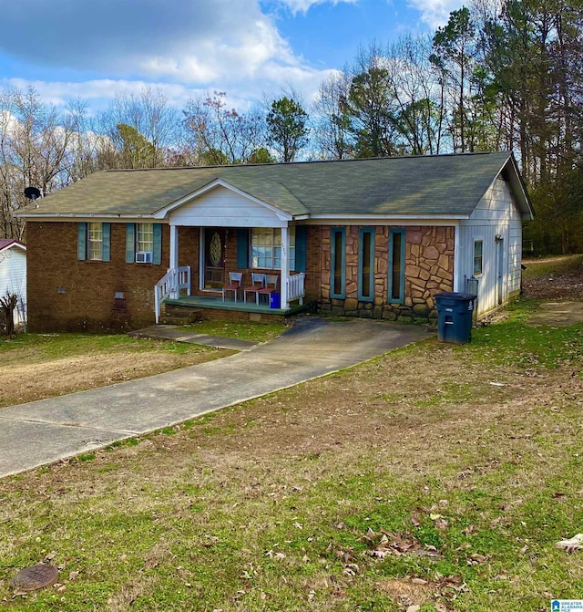 ranch-style house with covered porch and a front lawn