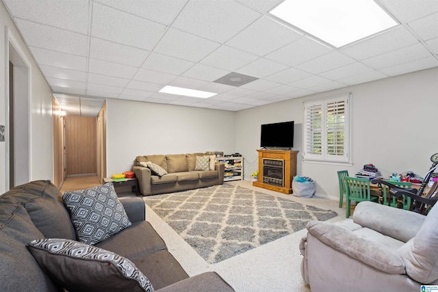 living room featuring a paneled ceiling and carpet