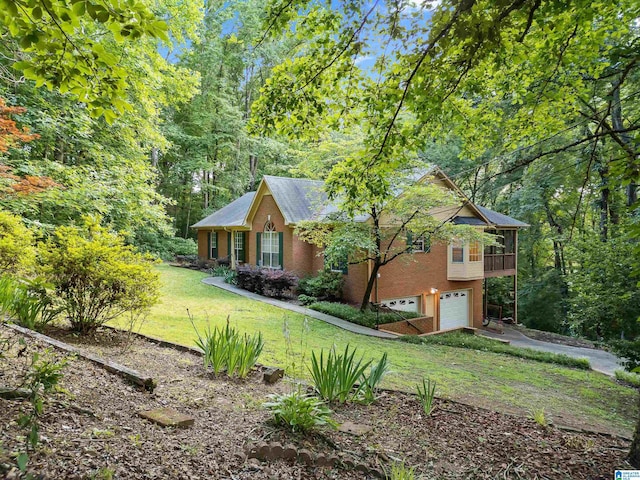 view of front of property featuring a garage, a sunroom, and a front lawn