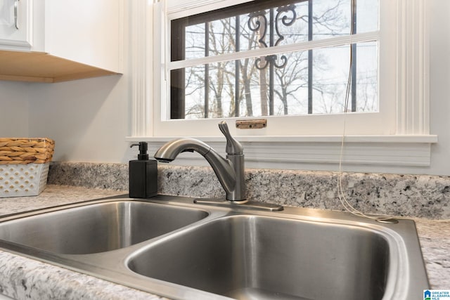 room details featuring sink and white cabinets