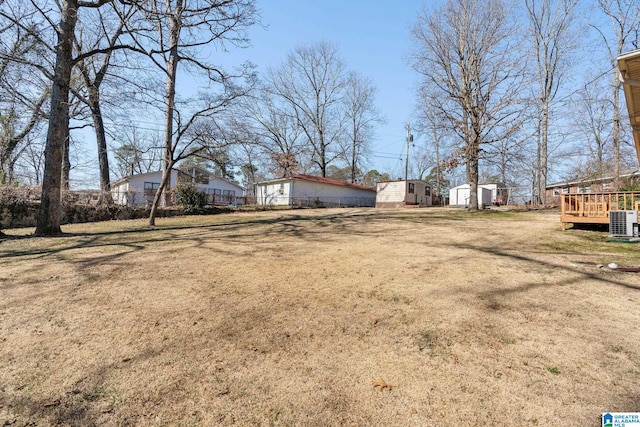 view of yard featuring a shed, central AC unit, and a deck