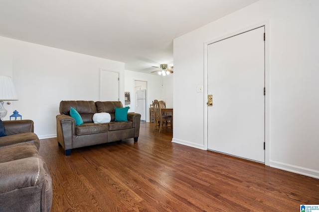 living room featuring dark wood-type flooring and ceiling fan