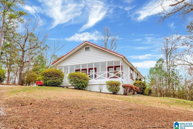 view of front of property featuring a front yard and a sunroom