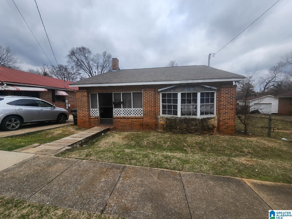 bungalow-style home with a front lawn