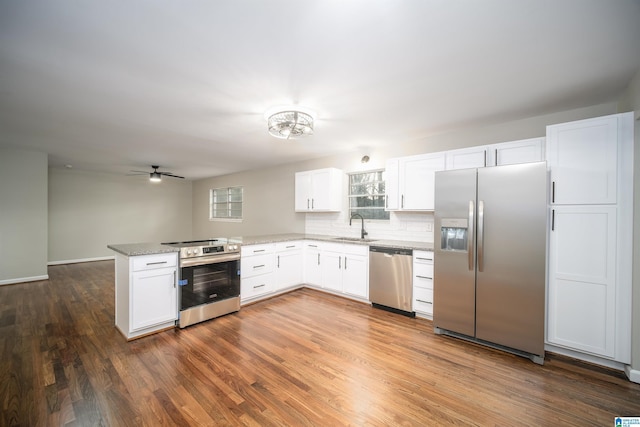 kitchen featuring white cabinetry, sink, stainless steel appliances, and kitchen peninsula