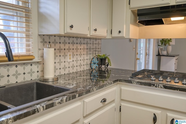 kitchen featuring tasteful backsplash, sink, and white cabinets