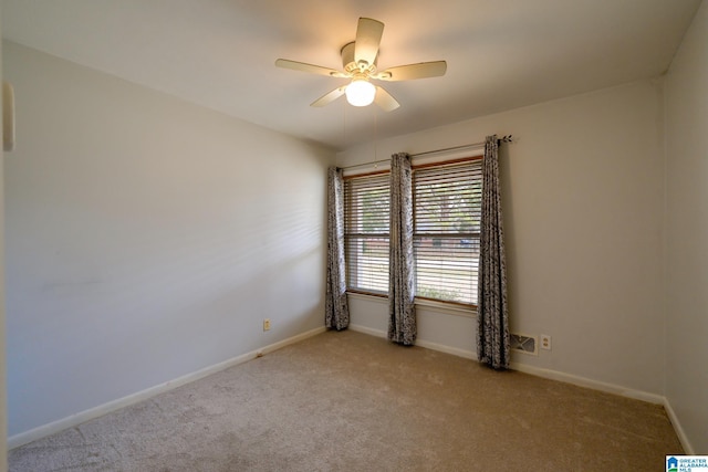 spare room featuring light carpet and ceiling fan