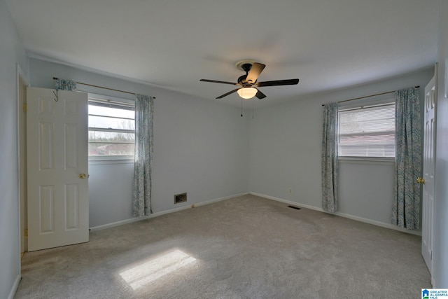 carpeted spare room with ceiling fan