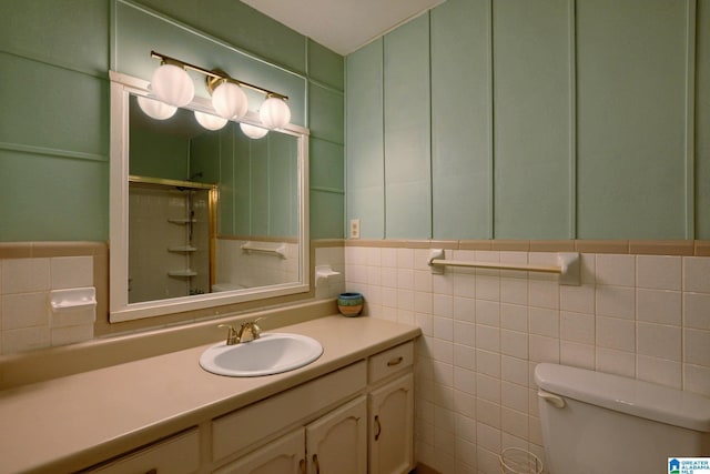 bathroom featuring tile walls, vanity, a shower with door, and toilet