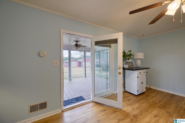 doorway to outside with crown molding, ceiling fan, and light hardwood / wood-style flooring