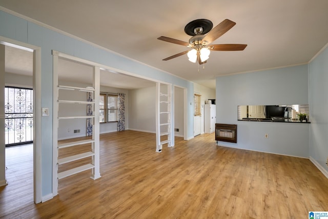 unfurnished living room featuring crown molding, plenty of natural light, and light hardwood / wood-style floors