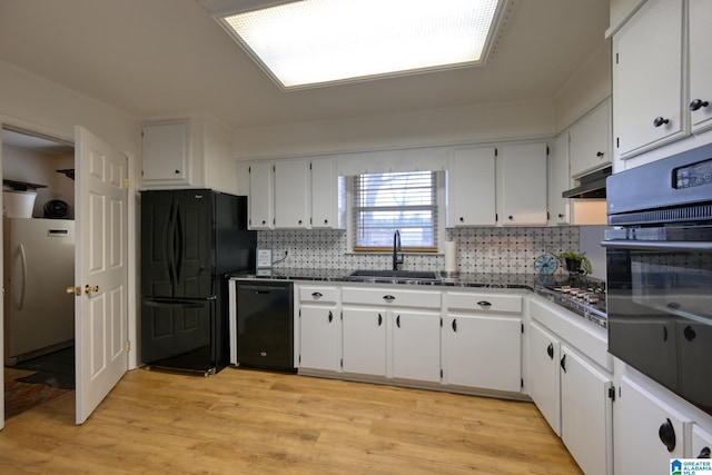 kitchen featuring sink, tasteful backsplash, black appliances, light wood-type flooring, and white cabinets