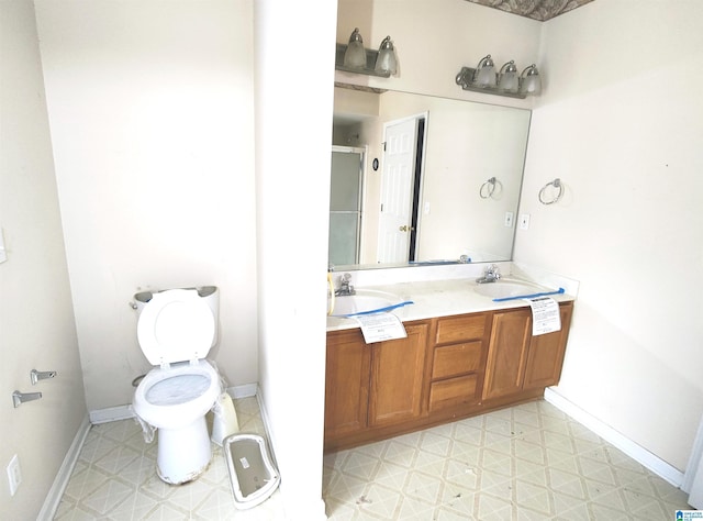 bathroom featuring vanity, a shower with shower door, and toilet