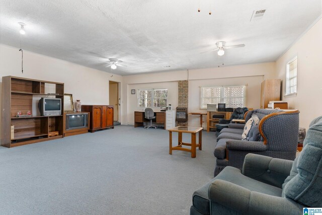 carpeted living room with a healthy amount of sunlight, a textured ceiling, and ceiling fan