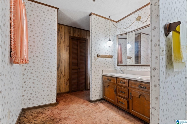 bathroom with crown molding, vanity, and a textured ceiling