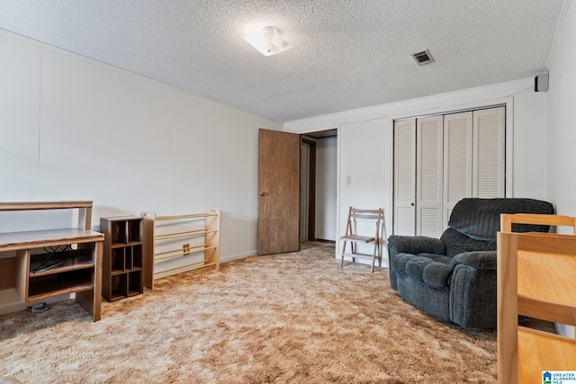 sitting room featuring carpet and a textured ceiling