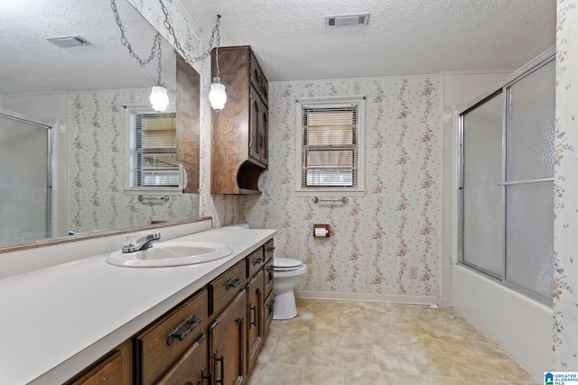 full bathroom featuring vanity, combined bath / shower with glass door, a textured ceiling, and toilet