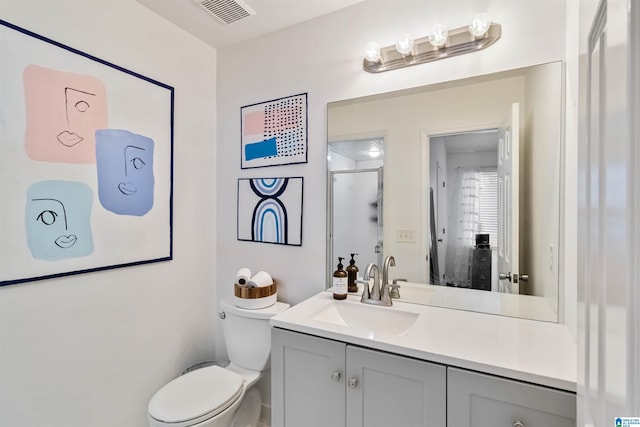 bathroom with vanity, toilet, and a shower with door