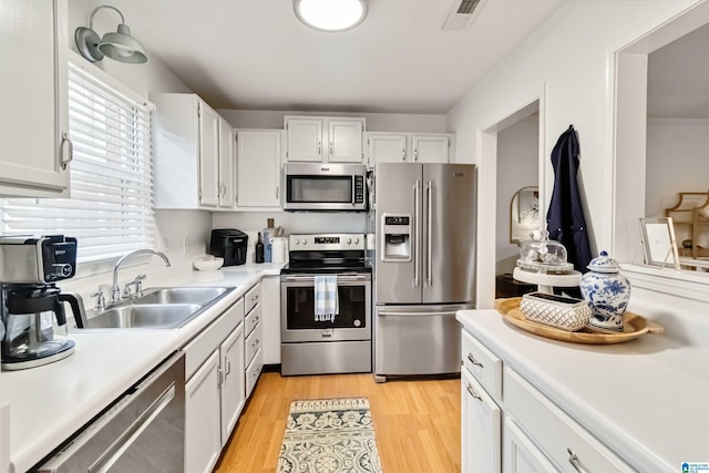 kitchen featuring sink, light hardwood / wood-style flooring, stainless steel appliances, and white cabinets