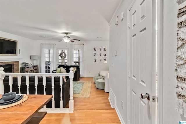 interior space featuring ceiling fan, a fireplace, and wood-type flooring