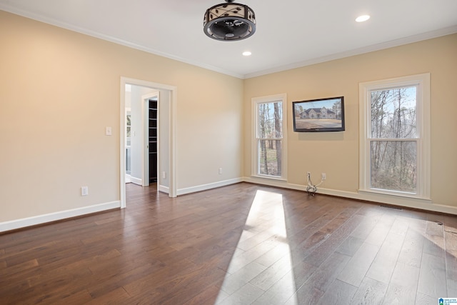 spare room with ornamental molding and dark hardwood / wood-style floors