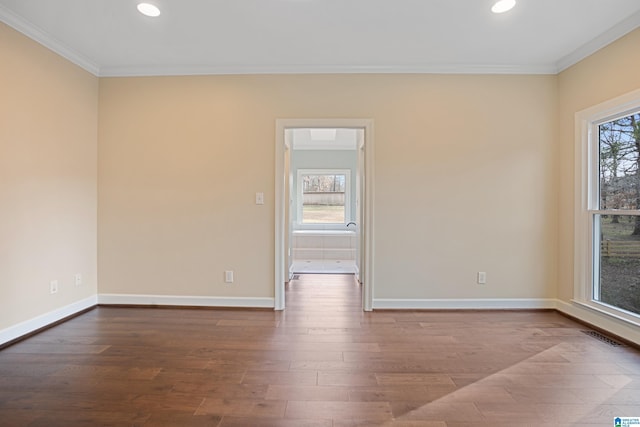 spare room with crown molding, a healthy amount of sunlight, and wood-type flooring