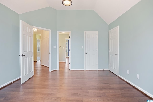 unfurnished bedroom with lofted ceiling and wood-type flooring