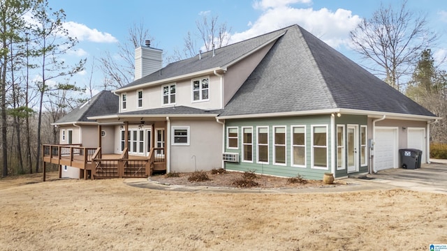 rear view of property featuring a wooden deck and a garage