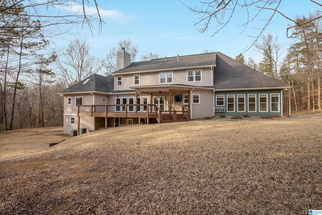 back of house with a lawn and a deck