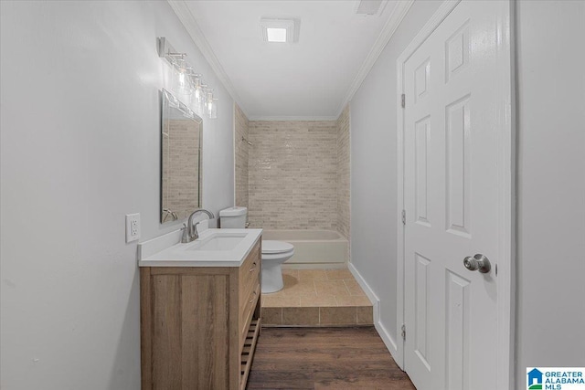 full bathroom featuring ornamental molding, toilet, tiled shower / bath combo, and vanity