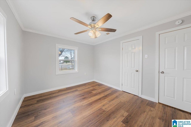 unfurnished bedroom with ceiling fan, ornamental molding, and dark hardwood / wood-style floors