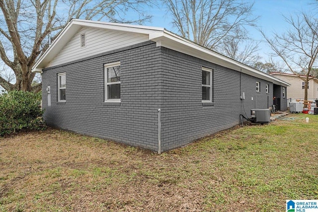 view of side of property with central AC and a lawn