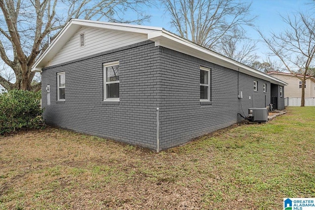 view of side of home featuring central AC and a yard