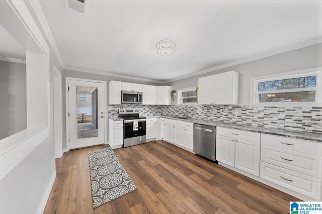 kitchen with sink, white cabinets, stainless steel appliances, light stone countertops, and dark wood-type flooring