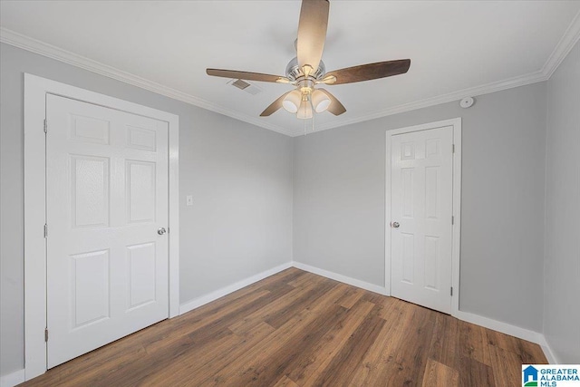 empty room featuring crown molding, dark wood-type flooring, and ceiling fan